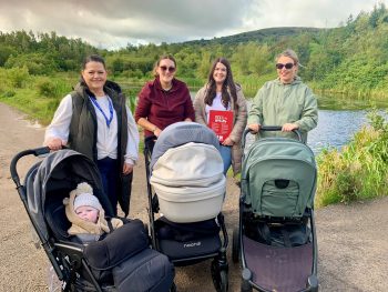 Taking the strides to the top of Colin Glen Forest Park are South Eastern Trust Health Visitor Natasha Higgins with little Cònall Stanley, Jacqueline Hyland with her daughter Éireann May Hyland, Colin Neighbourhood Partnership’s Early Intervention Support Worker Danielle Hyland and Fionnuala Pimley with her daughter Ría Hawkins