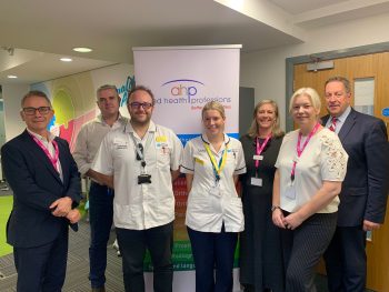L-R Deputy Chief Executive, Executive Director of Nursing, Midwifery and AHPs & Director of Support Services, David Robinson, Non-Executive Director Kevin McMahon, Radiographer Chris Robinson, Podiatrist Zara Robinson, Assistant Director, AHP Workforce, Julie Alexander, Assistant Director, Allied Health Professions (AHPs), Joanne Shannon and South Eastern Trust Chairman Jonathan Patton