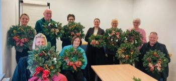 Group of foster carers proudly showing their christmas wreaths