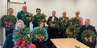 Group of foster carers proudly showing their christmas wreaths
